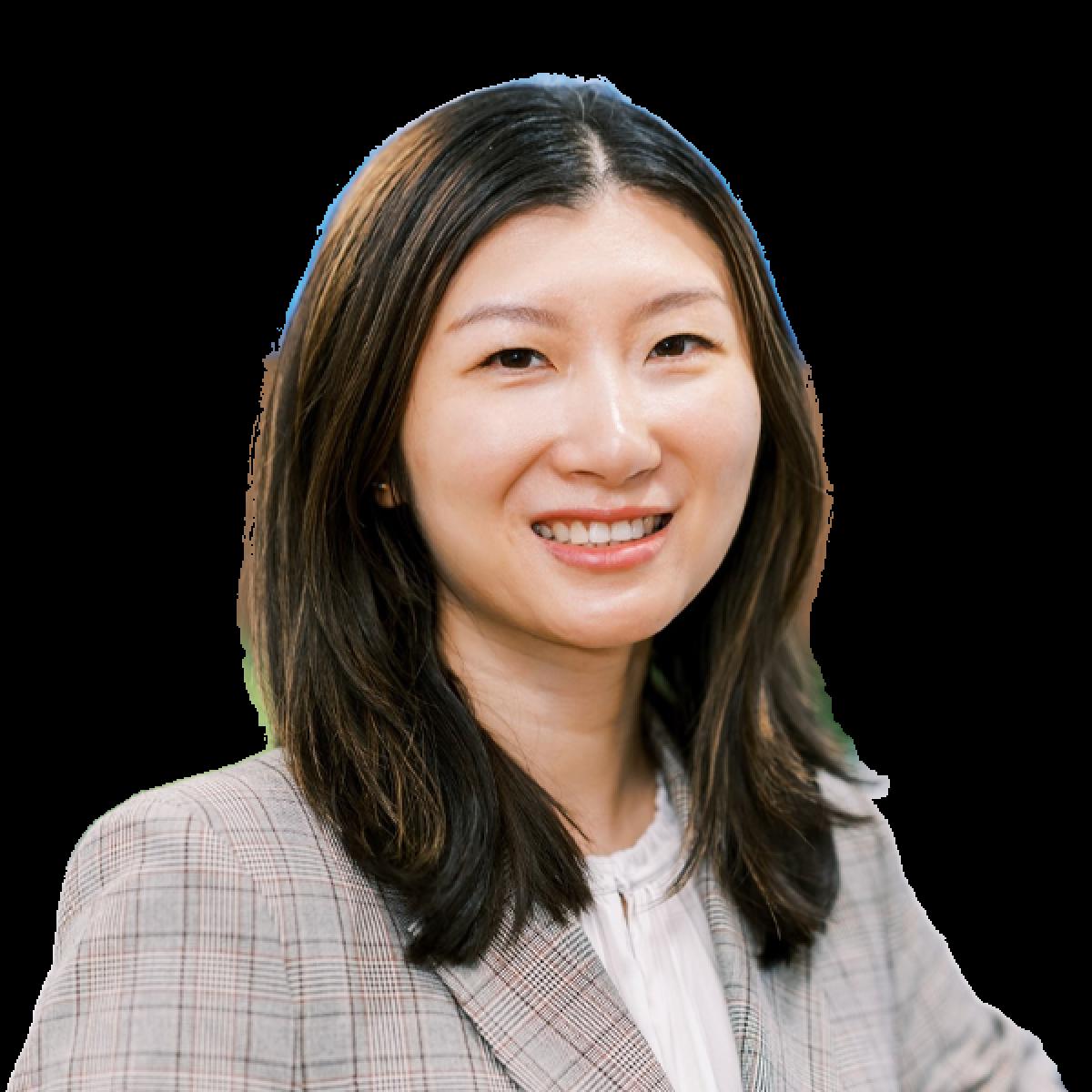 Professional female doctor smiling warmly in grey checked blazer against white background